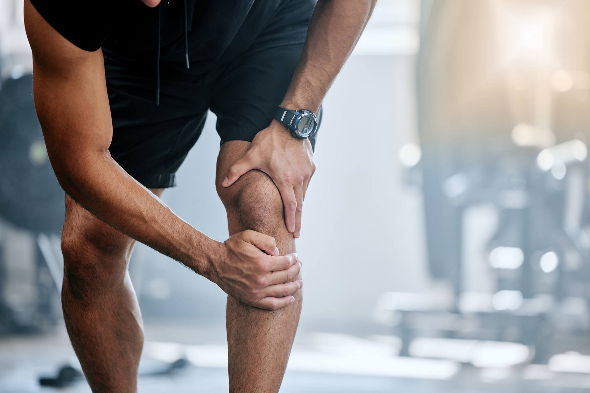 Bildausschnitt eines Mannes mit Knieschmerzen beim Sport.