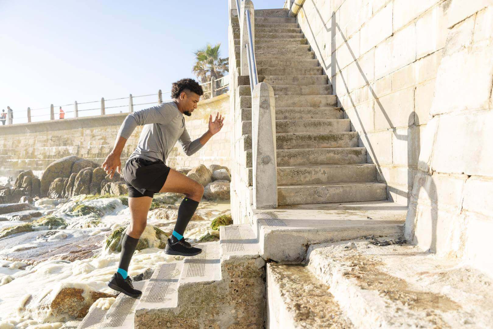 Ein Mann joggt eine Treppe hoch. Dabei trägt er Performance Running Socks von Bauerfeind Sports.